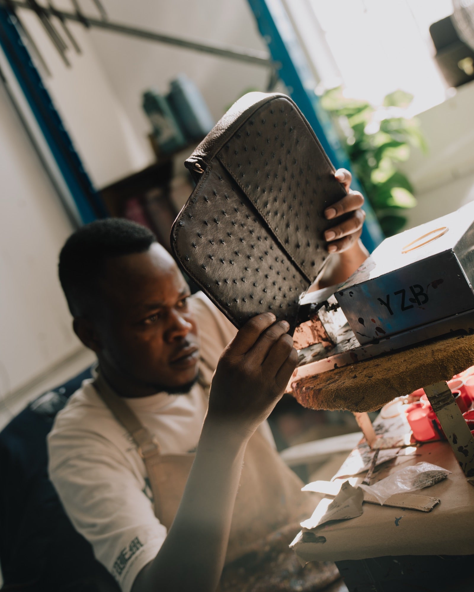A Tuska artisan inspecting an ostrich leather bag in the atelier